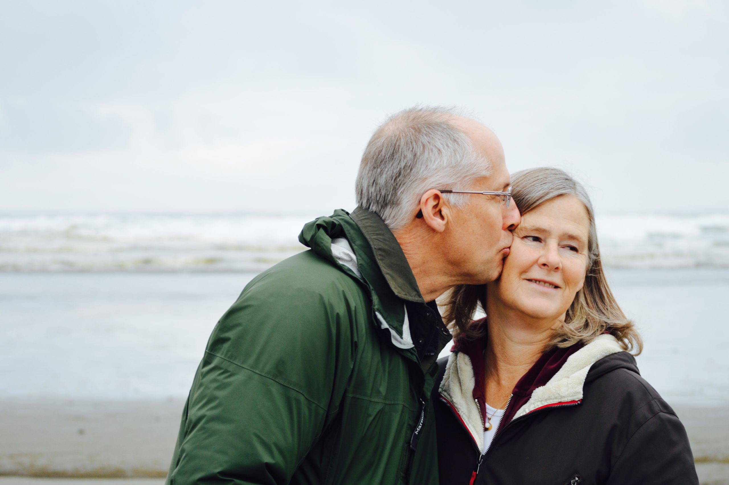 Senior couple walking on the beach - People generally have a longer life expectancy these days - here are 5 ways you can promote your health as a senior during your golden years.